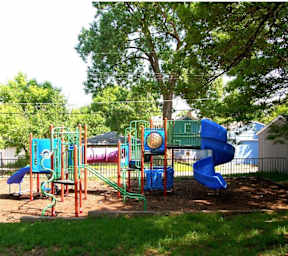 A playground with a blue slide and a green slide.