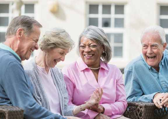 Four seniors are laughing and talking together.