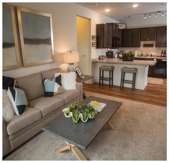 A modern living room with a grey coffee table and a beige couch.