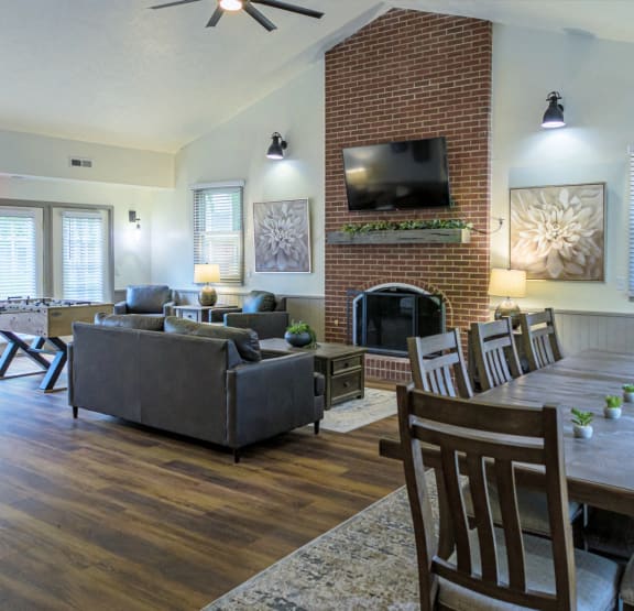 a living room with a brick fireplace and a table with chairs