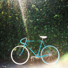 a blue bike parked next to a green wall