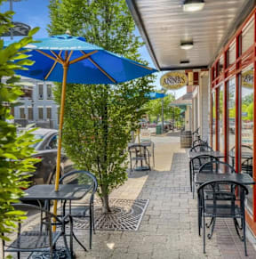 a patio with tables and umbrellas outside of a restaurant