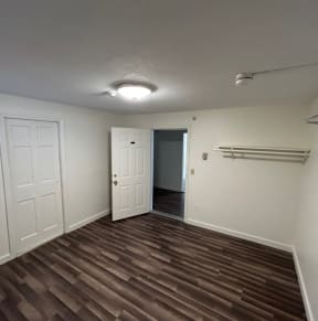a living room with a hardwood floor and white walls