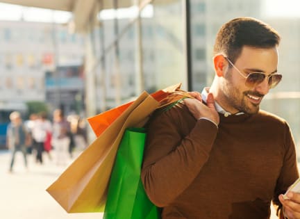 a man walking down the street with shopping bags