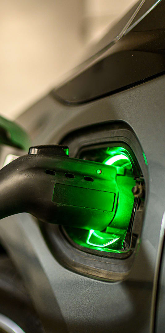 An electric car is charging at a station.