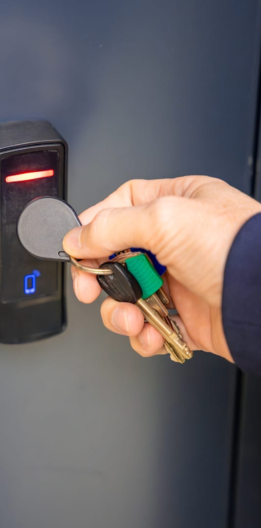 A person is inserting a key into a lock with a red light on.