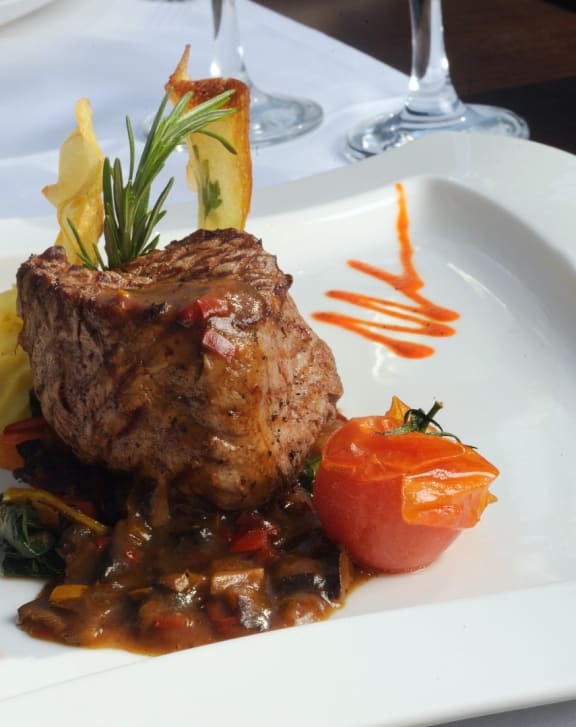 a plate of food with steak and vegetables on a table
