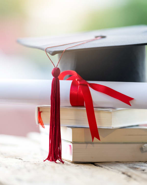 a graduation cap on top of a stack of books