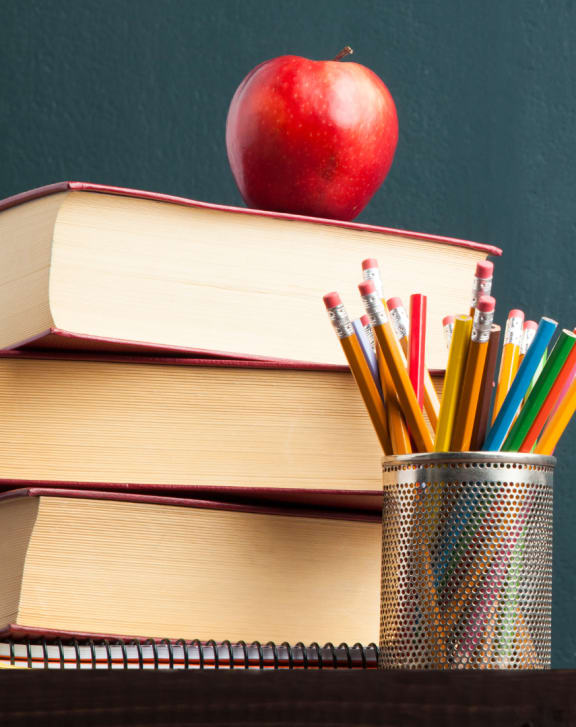 an apple sitting on top of a stack of books