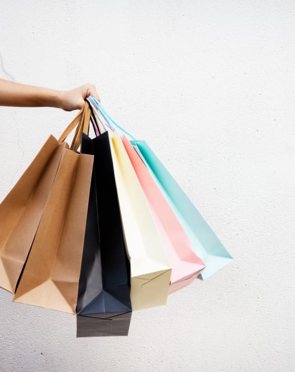 a hand holding a bunch of shopping bags