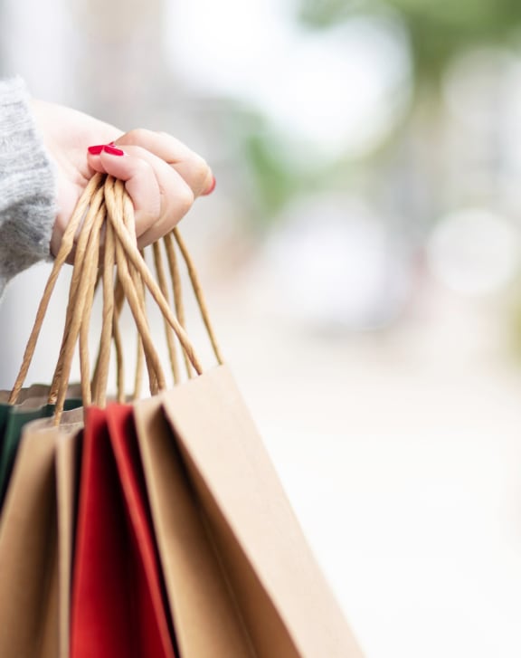 a woman holding a bunch of shopping bags in her hand