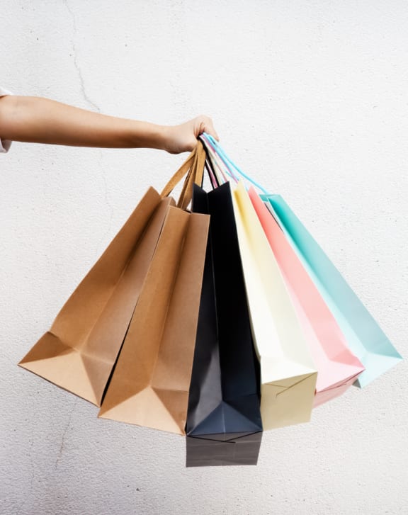 a hand holding a bunch of shopping bags