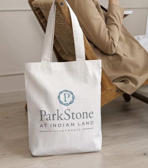 A white tote bag with the logo of ParkStone at Indian Land Apartments.