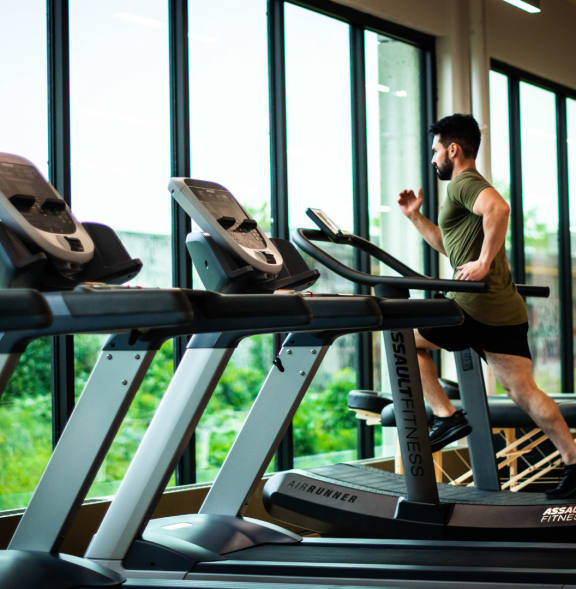 a man running on a treadmill in a gym