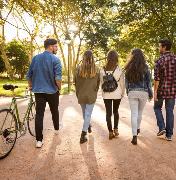 a group of people walking down a park