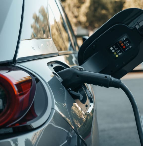 a electric car is plugged into a gas pump