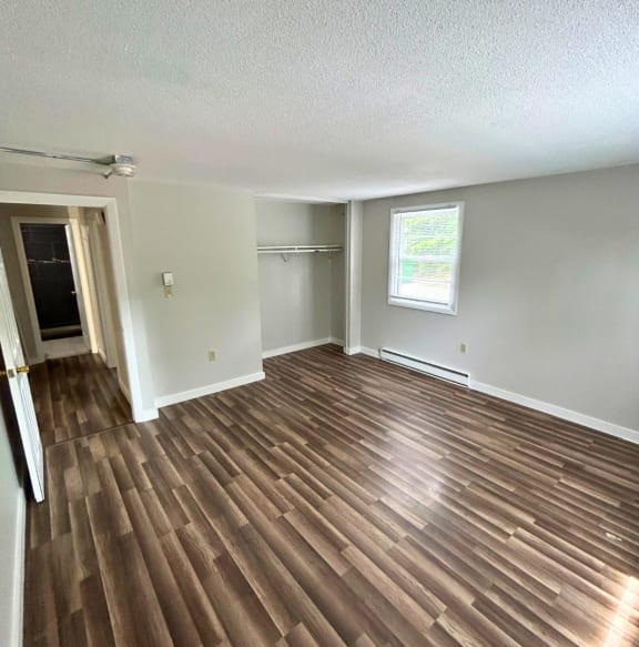 an empty living room with a hardwood floor