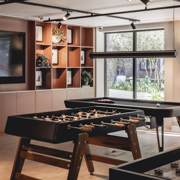 A foosball table sits in a room with a wood and tile floor.