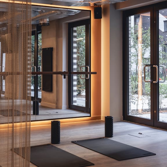 A room with a glass door and a black mat on the floor.