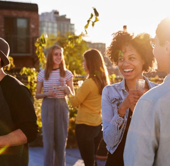 a group of people standing around talking and drinking wine