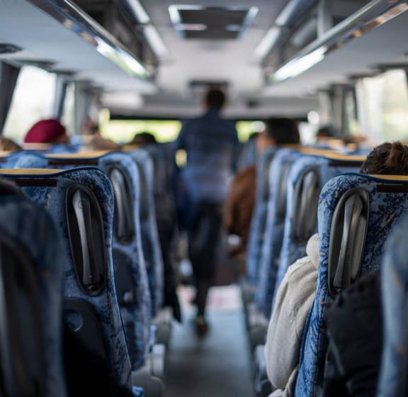 the inside of a bus with people walking down the aisle