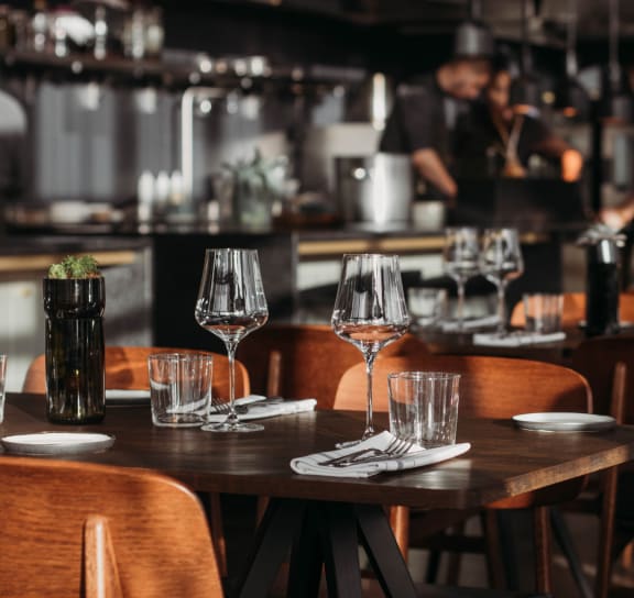 a wooden table with wine glasses at a restaurant