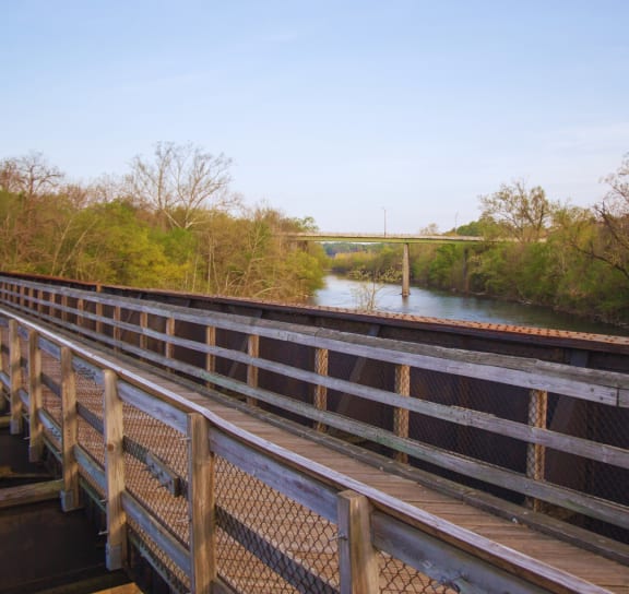 a train bridge over a river with a bridge in the background