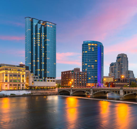 a city skyline with a river and skyscrapers at night