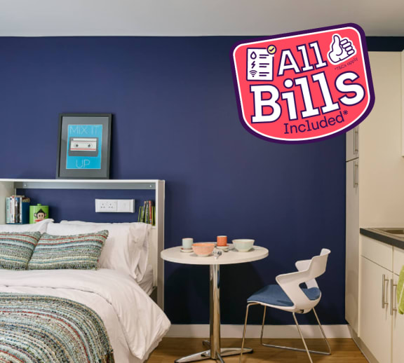 a bedroom with a blue wall and a white bed with a multicolored comforter