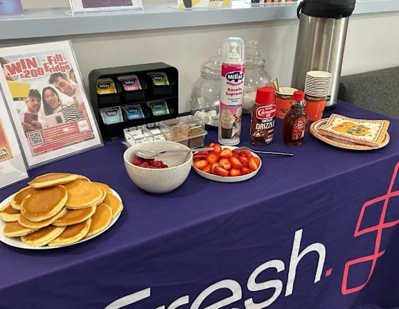 A table with a purple cloth that says fresh on it.