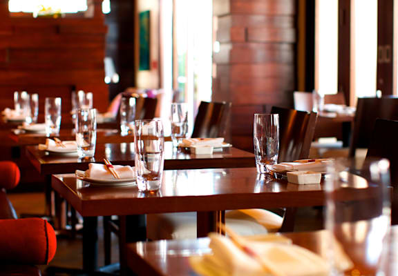 A restaurant with wooden tables and chairs is ready for customers.