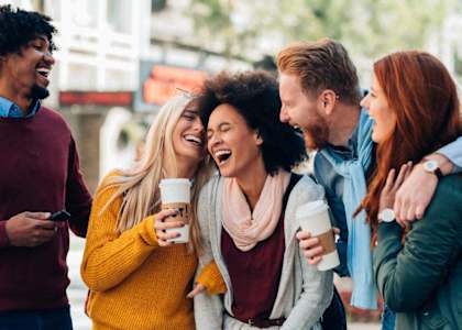 a group of people laughing and drinking coffee