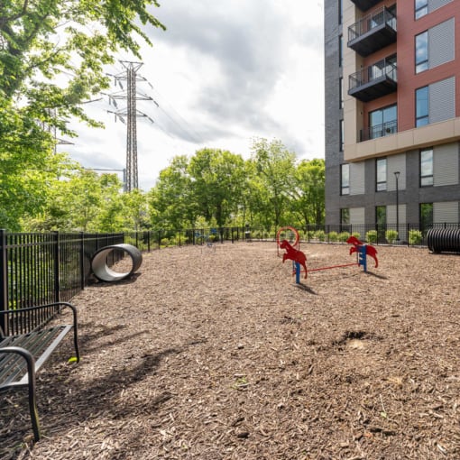 two children playing in a playground next to an apartment building