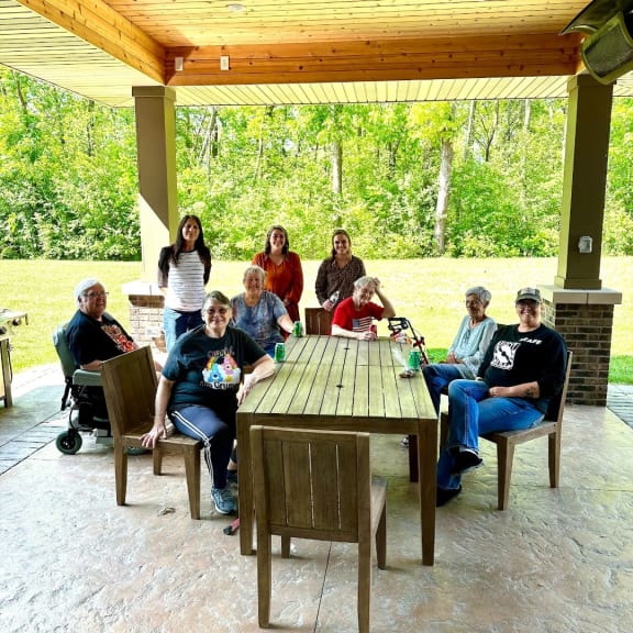 people at a covered patio with a table and chairs