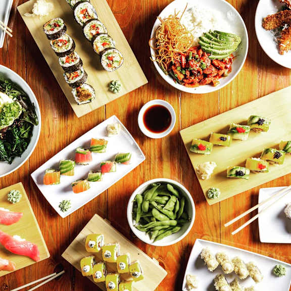 A variety of Asian dishes are displayed on a wooden table.