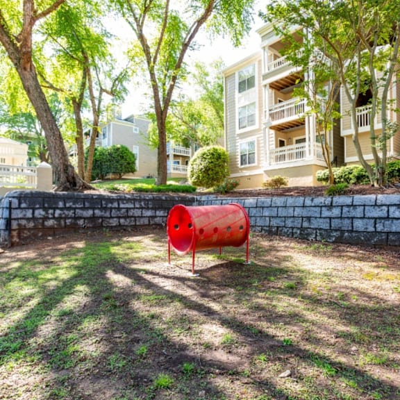 a red barrel sits in the grass in front of an apartment building at Beacon Ridge Apartments, Greenville, SC, 29615