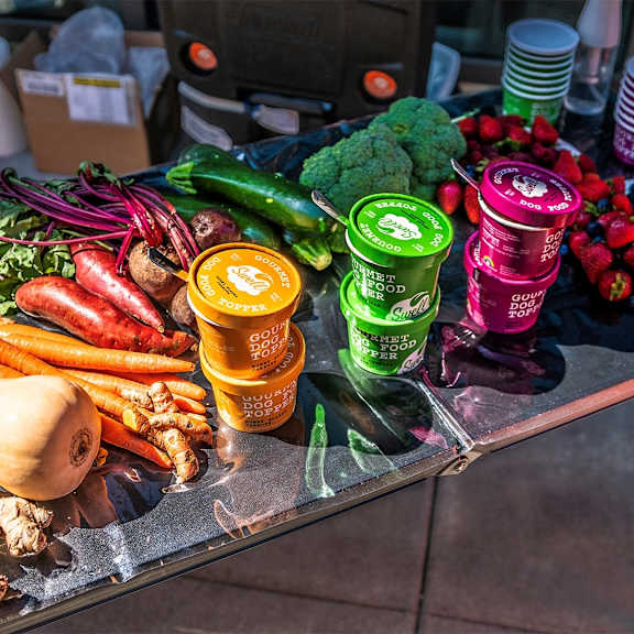 a table full of fruits and vegetables and cans of juice