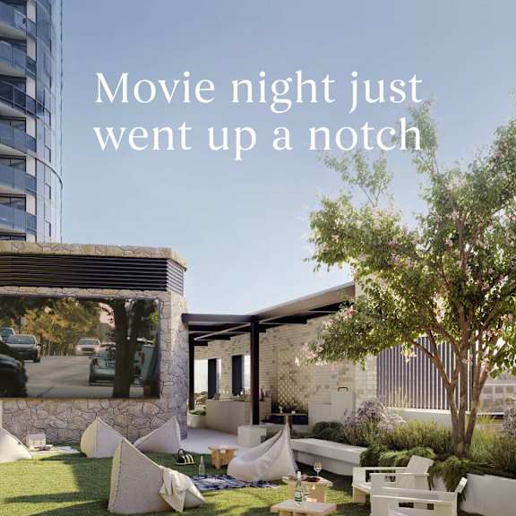 A modern outdoor movie theater setup with a large screen and comfortable seating.