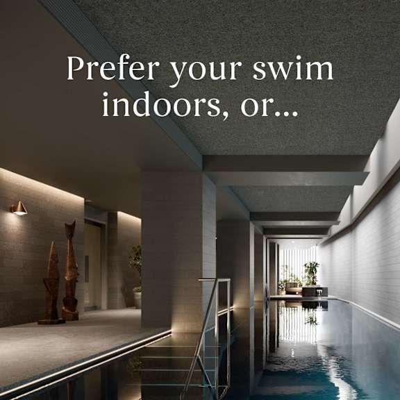 A modern indoor swimming pool with a staircase leading down to it.