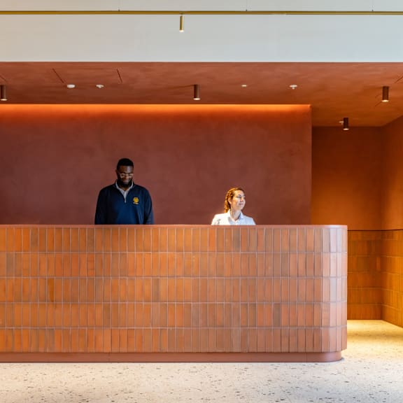 Two members of the concierge team standing behind the reception desk.