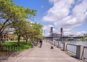 Thumbnail 5 of 10 - Man and Woman Riding Bikes Along River in Portland, Oregon