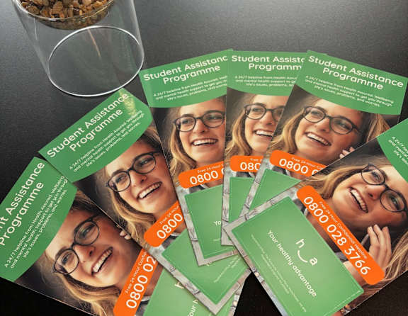 A stack of green business cards for a student assistance program.