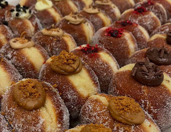 A tray of assorted doughnuts with various toppings.