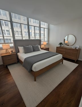 A grey couch with a wooden coffee table in front of it.