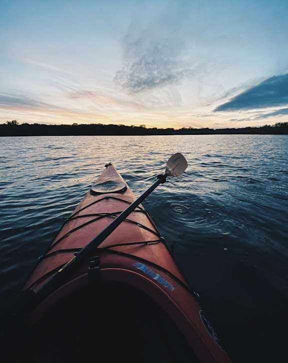 A red kayak is seen from the inside with a sunset in the background at River Crossing Apartments, Thunderbolt, GA, 31404