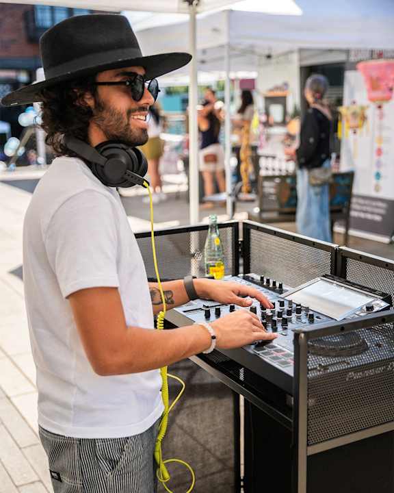 a man wearing a hat and headphones playing music on a keyboard