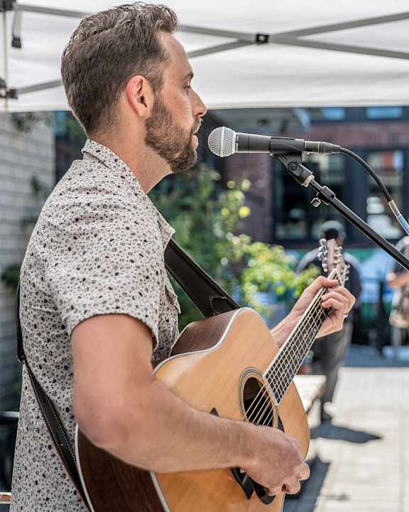 a man singing into a microphone while holding a guitar