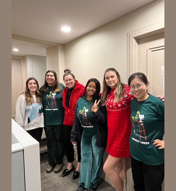A group of people wearing green shirts with a Christmas tree design.