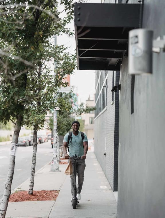 a man riding a bike down a sidewalk