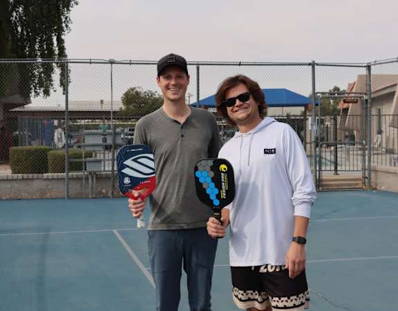 Two men standing on a tennis court.